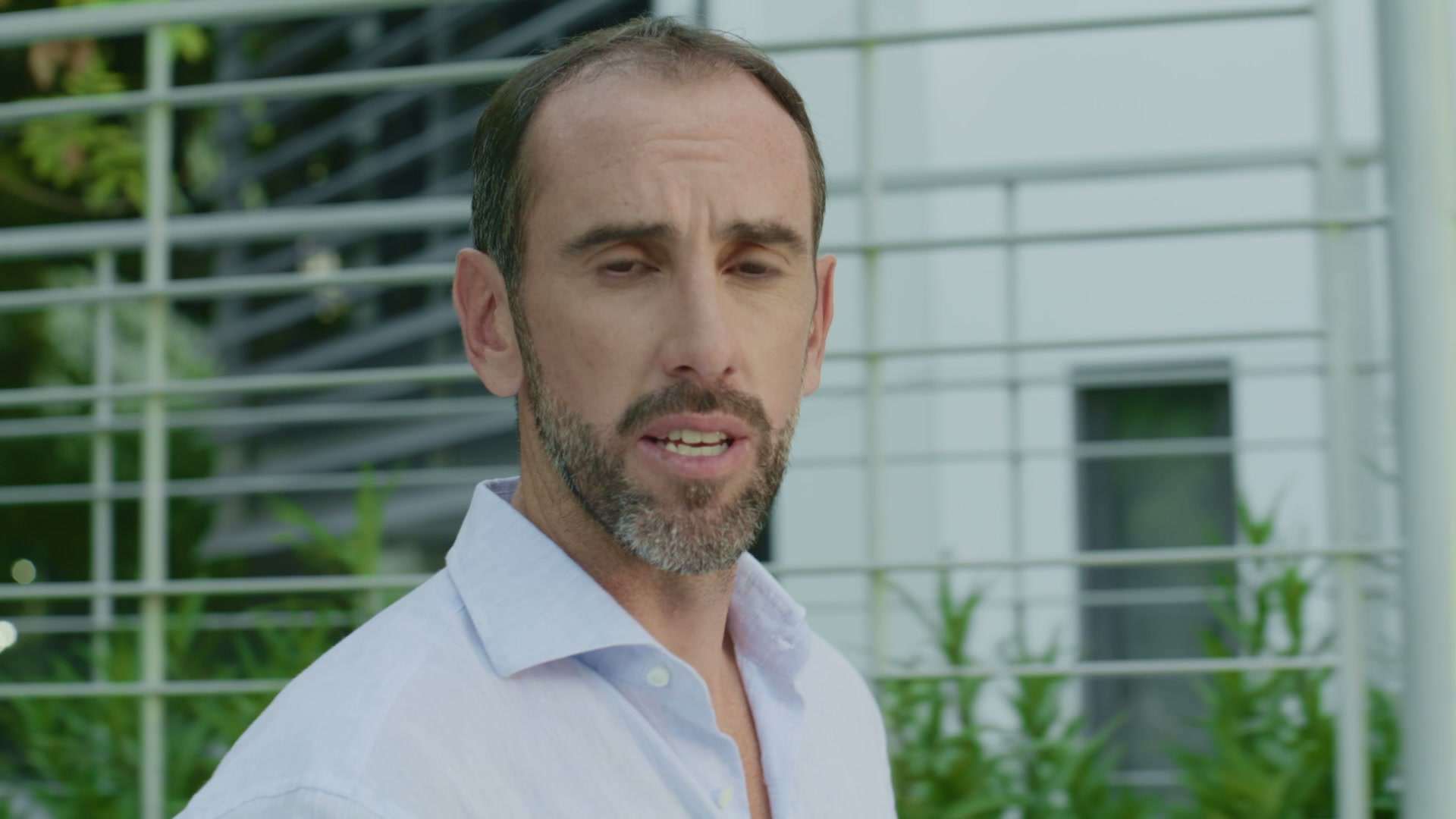 Primer plano de Diego Godín mirando a cámara con edificios de vidrio detrás