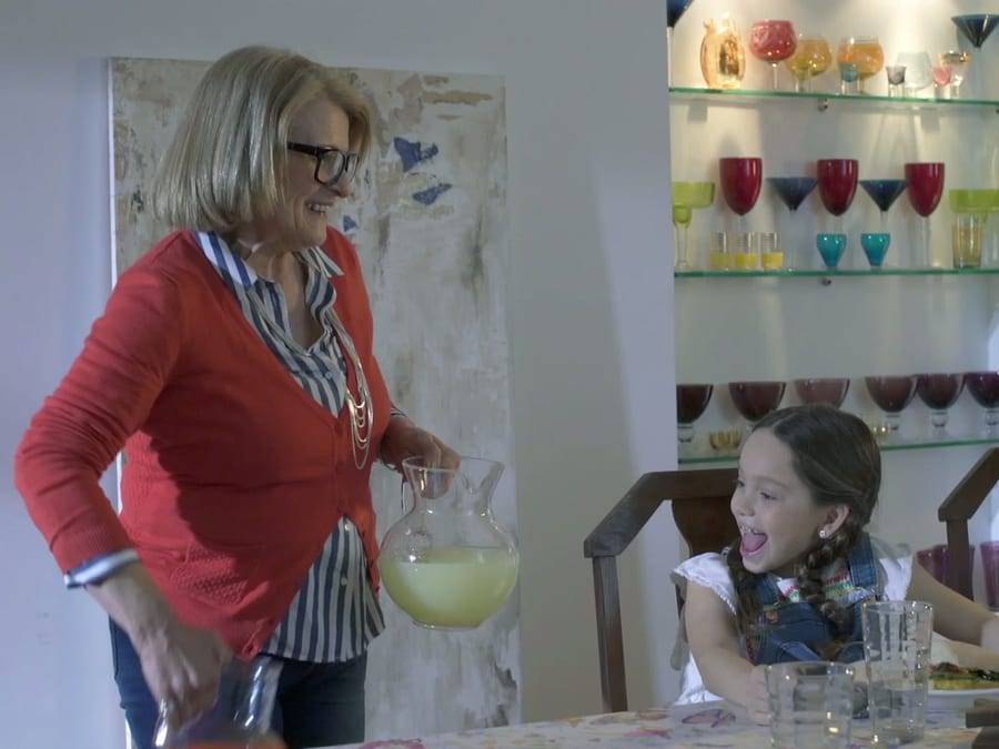 Cuadro del spot de Juguito: una mujer sirve jugo a una niña que sonríe en la mesa