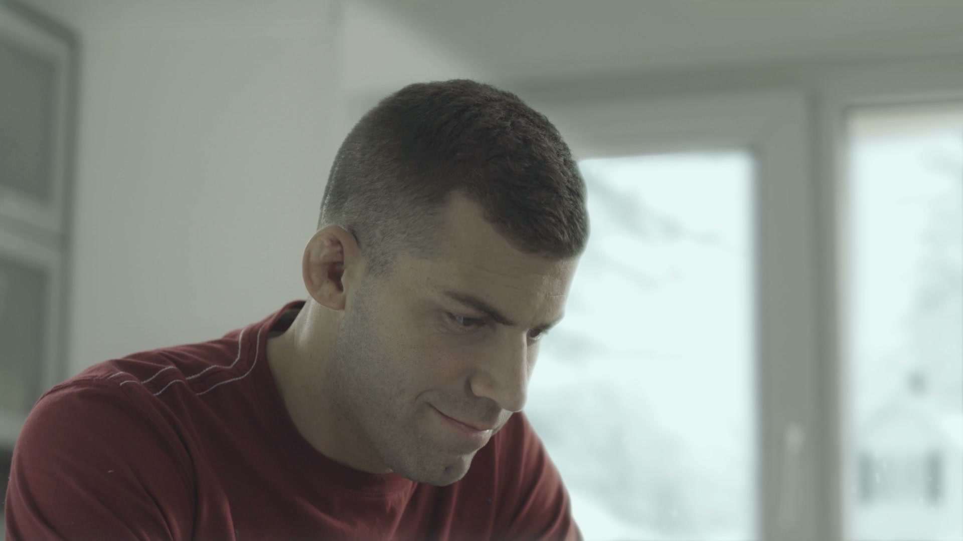 Retrato de Tonga Reyno mirando hacia abajo en una cocina, con la ventana a un costado